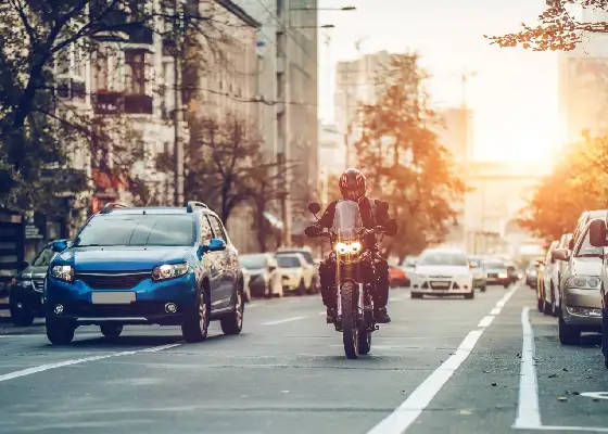 car and motorbike on road in the city
