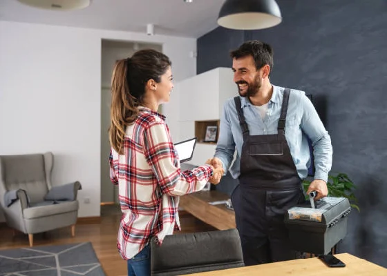 Woman and men with a tool box shaking hands 
