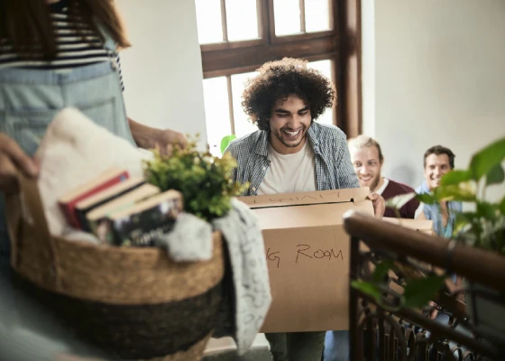 Young adults moving boxes on stairs
