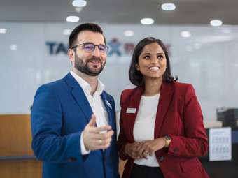 eine Mitarbeiterin und ein Mitarbeiter der Targobank, die vor einer Filiale stehen